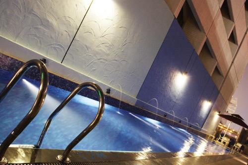 a swimming pool in a hotel with ailed wall at Hotel Royal Queens in Singapore