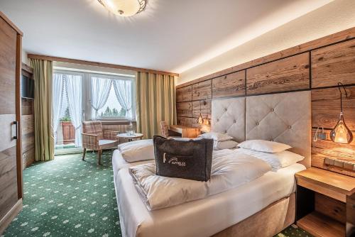 a hotel room with a bed with a large headboard at Naturhotel Alpenblick in Maurach