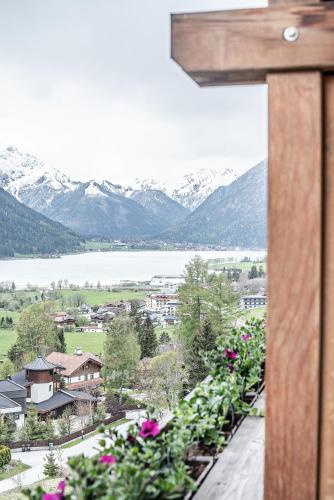a cross on the side of a building with flowers at Naturhotel Alpenblick in Maurach