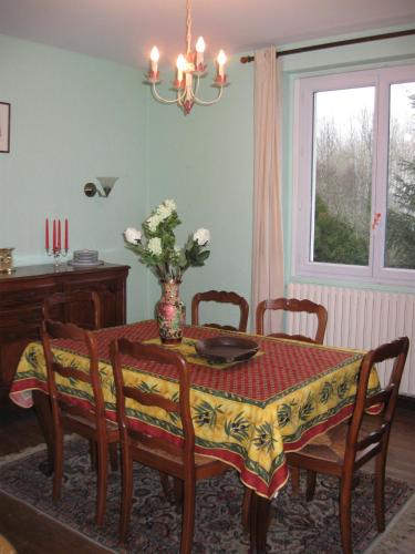 La Chapelle-FaucherにあるAu Catalpaのダイニングルーム(椅子とテーブル、花瓶付)
