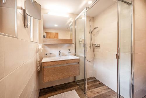 a bathroom with a sink and a shower at Naturhotel Alpenblick in Maurach