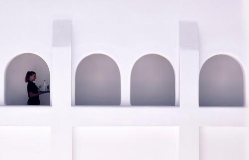 a woman is standing in a white room at Kalisti Hotel & Suites in Fira