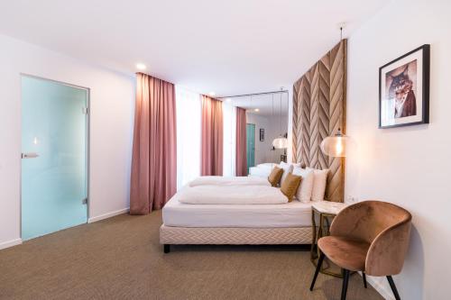 a hotel room with a bed and a chair at Filitti Boutique Hotel in Bucharest