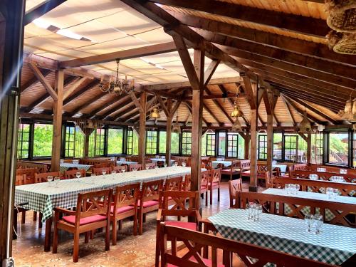 a dining room with tables and chairs in a building at Pensiunea Apfelhaus in Cisnadioara
