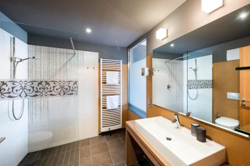 a bathroom with a sink and a shower and a mirror at ALIA appartements & wellness in Lagundo
