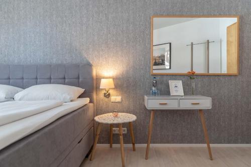 a bedroom with a bed and a mirror and a table at Hotel Am Dom in Bamberg