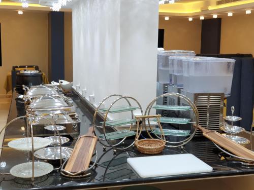 a buffet with plates and utensils on a table at Lamar Al Bawadi Hotel in Jeddah