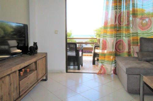 a living room with a television and a couch at Blue View Seaside Luxury Apartments in Ixia