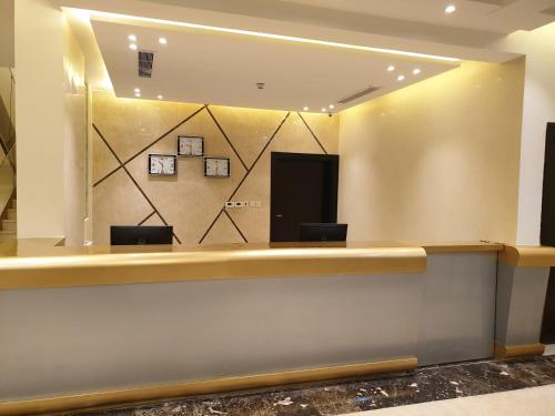 a lobby with a reception counter with two chairs at Lamar Al Bawadi Hotel in Jeddah