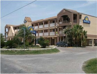 a large building with a car parked in front of it at Days Inn by Wyndham Corpus Christi Beach in Corpus Christi
