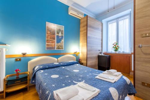 um quarto azul com uma cama com toalhas em Alessandro A San Pietro Best Bed em Roma