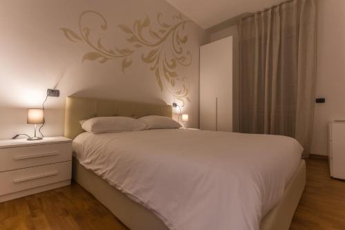 a bedroom with a large white bed and two lamps at LM House in Lonato del Garda