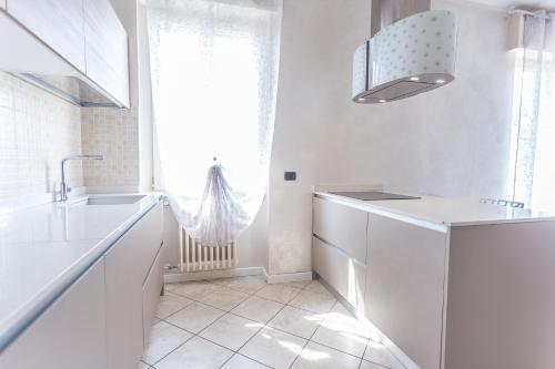 a white kitchen with a sink and a window at LM House in Lonato del Garda