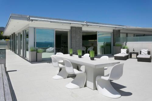 a patio with a white table and chairs at Sacred Waters Taupo in Taupo