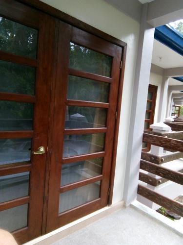 a wooden door with glass panels on a house at Ferellee Beach Front Inn in San Vicente