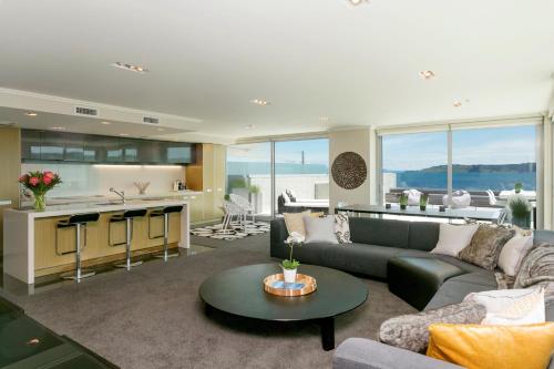 
a living room filled with furniture and a large window at Sacred Waters Taupo in Taupo
