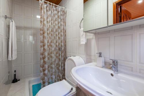 un bagno bianco con lavandino e WC di Casa das Bonecas a Vieira do Minho