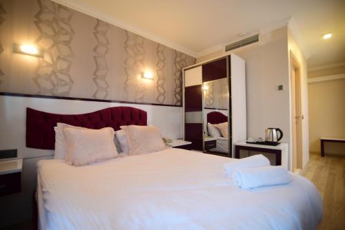a bedroom with a large white bed with two pillows at Özdemir Palas in Ankara