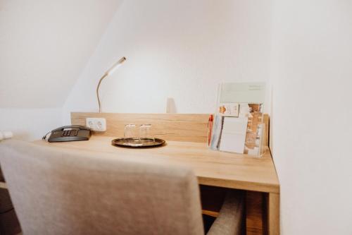a desk with a lamp and a phone on it at Hotel Frauensteiner Hof in Frauenstein