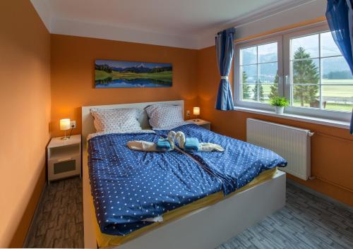um quarto com uma cama com um edredão azul em Kukoricza Hacienda em Bad Mitterndorf