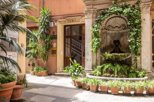 a fountain in front of a building with plants at Hotel Gea Di Vulcano in Rome