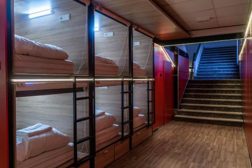 a room with four bunk beds with a staircase at Hostel Inbox in Skopje