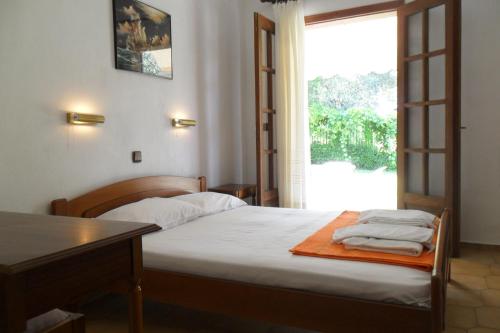 a bedroom with a bed and a table and a window at Viki Studios and Apartments in Skala Potamias