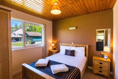 a bedroom with a bed with two towels on it at Logierait Pine Lodges in Pitlochry