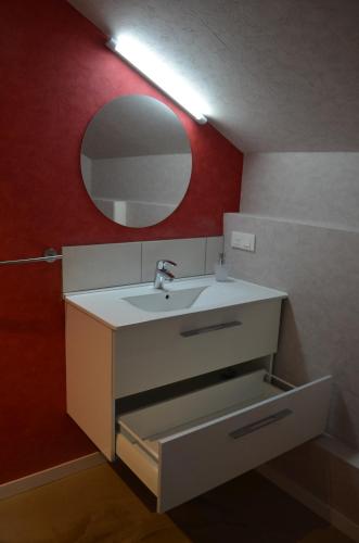 bagno con lavandino e specchio di Chambres d hotes joel a Rhinau