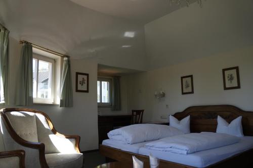 a bedroom with two beds and a chair and a window at Villa am Park in Bad Tölz