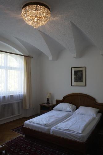 a bedroom with a large bed and a chandelier at Villa am Park in Bad Tölz