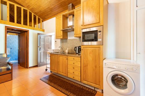 a kitchen with a washer and a washing machine at Quinta do Rio Homem in Caldelas