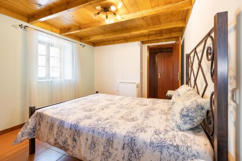 a bedroom with a bed with a wooden ceiling at Quinta do Rio Homem in Caldelas