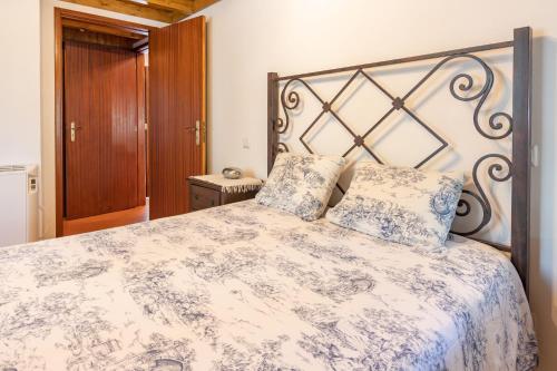 a bedroom with a large bed with blue and white sheets at Quinta do Rio Homem in Caldelas