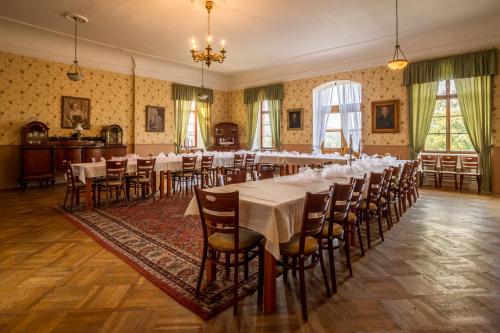 a large room with tables and chairs in it at Zámek Lobeč in Lobeč