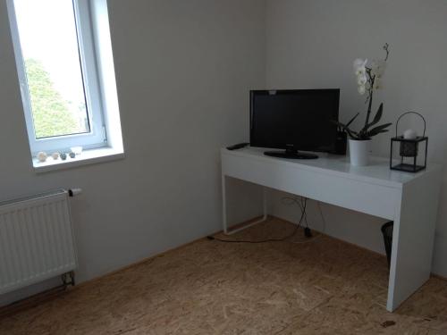 a white desk with a television on top of it at Apartmány U splavu in Veselí nad Moravou