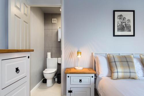 1 dormitorio con 1 cama, aseo y lámpara en Holyrood Skyline Apartment, en Edimburgo