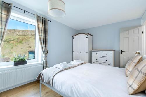 sypialnia z dużym łóżkiem i oknem w obiekcie Holyrood Skyline Apartment w Edynburgu
