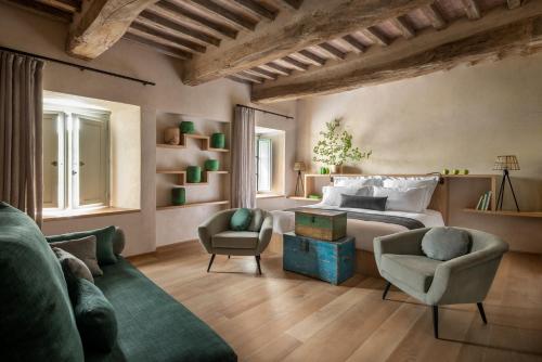 a bedroom with a bed and a couch and chairs at Badia di Pomaio in Arezzo