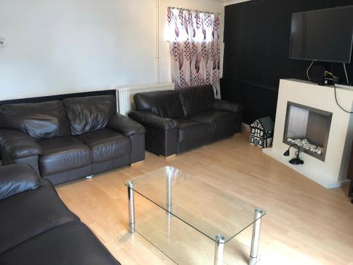 a living room with a leather couch and a glass coffee table at Florence Court Andover in Andover