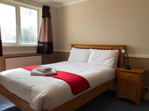 a bedroom with a bed with a red blanket at Florence Court Andover in Andover