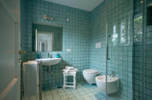 カプリにあるCAPRI TIBERIO'S DREAMの青いタイル張りのバスルーム(洗面台、トイレ付)