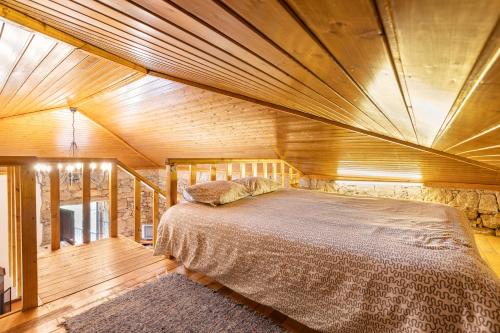 a bedroom with a large bed with a wooden ceiling at Quinta do Rio Homem in Caldelas