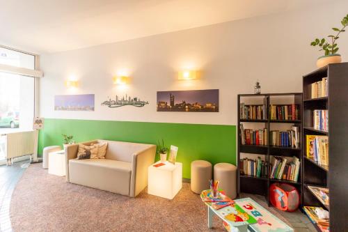 un salon avec un canapé et une étagère dans l'établissement Hotel Markgraf Leipzig, à Leipzig