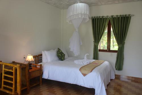 een slaapkamer met 2 bedden en een raam bij Tra Vinh Lodge in Nguyệt Hạng