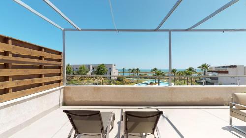 a balcony with two chairs and a view of the city at Apartment Altos Del Rompido in El Rompido