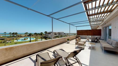 een balkon met stoelen en uitzicht op de oceaan bij Apartment Altos Del Rompido in El Rompido