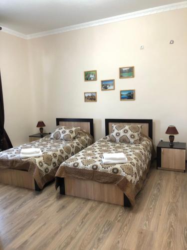 dos camas sentadas una al lado de la otra en un dormitorio en Saroy Guest house, en Samarkand