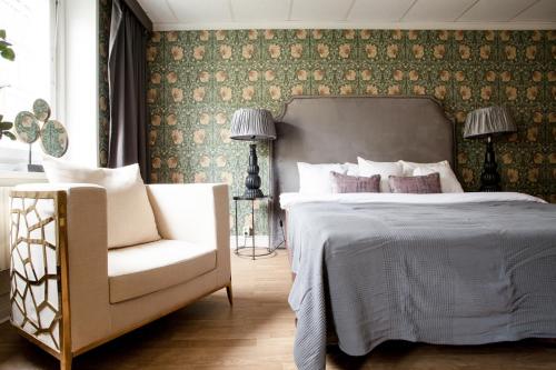 a bedroom with a bed and a chair at Centric Hotel in Norrköping