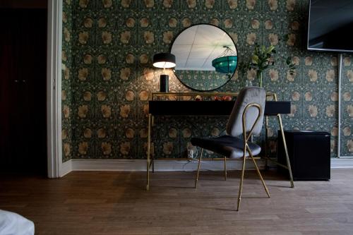 a mirror and a chair in a room at Centric Hotel in Norrköping